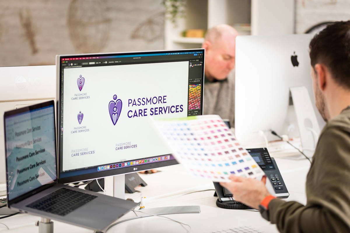 web designer in stockport working at computer looking at logo designs and colour swatches for branding